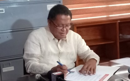 <p><strong>FIRST EO.</strong> Newly elected Binmaley town Mayor Pedro Merrera III signs his first executive order on Thursday (June 30, 2022). The EO mandates the use of the town's official seal and name in all projects and properties.<em> (Photo by Hilda Austria)</em></p>