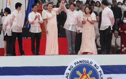 <p><strong>UNITY.</strong> President Ferdinand “Bongbong” Marcos Jr. (3rd from right) raises the hand of Vice President Sara Z. Duterte during his inauguration as the country's 17th Chief Executive at the National Museum of the Philippines in the City of Manila on Thursday (June 30, 2022). Both Marcos and Duterte won via a huge lead in the May 9 polls, each of them garnering more than 30 million votes. <em>(PNA photo by Avito C. Dalan)</em></p>