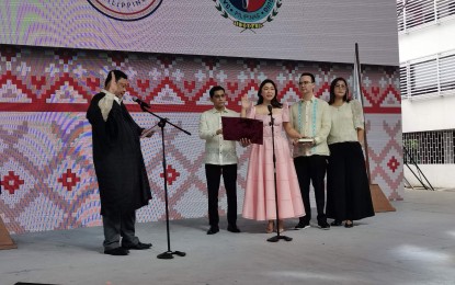 <p><strong>OATH TAKING.</strong> Taguig Mayor Lani Cayetano (in pink dress) takes her oath of office before Taguig regional trial court judge Antonio Olivete (left) at the Senator Rene “Campañero” Cayetano Memorial Science and Technology High School on Thursday (June 30, 2022). Cayetano is making a comeback after serving as mayor for three consecutive terms from 2010 to 2019. <em>(PNA photo by Lloyd Caliwan)</em></p>