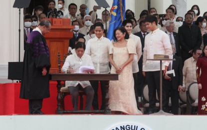 <p><strong>OATH OF OFFICE</strong>. President Ferdinand “Bongbong” Marcos Jr. signs his oath of office during his inauguration as the country’s 17th President at the National Museum of the Philippines in Manila on Thursday (June 30, 2022). Lawmakers congratulated him, expressing optimism that he would play a pivotal role in uniting the country toward "greater heights". <em>(PNA photo by Avito S. Dalan)</em></p>
