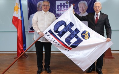 <p><strong>TURNOVER.</strong> Trade and Industry Secretary Alfredo Pascual (right) and his predecessor Ramon Lopez hold the agency's flag during the turnover ceremony held at the Board of Investments Penthouse in Makati City on June 29, 2022. Lopez has finished his six-year term, leaving a "sterling legacy," according to Pascual. <em>(Photo courtesy of DTI)</em></p>