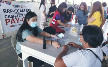 <p><strong>PAYOUT.</strong> Beneficiaries of the Department of Social Welfare and Development cash-for-work scheme receive their compensation of PHP4,200 in San Isidro, Nueva Ecija on Thursday (June 30, 2022). The 10-day Risk Resiliency Program-Climate Change Adaptation and Mitigation Disaster Risk Reduction employment program had the beneficiaries planting trees and other plants in backyard and community gardens. <em>(Photo courtesy of DSWD Region 3)</em></p>