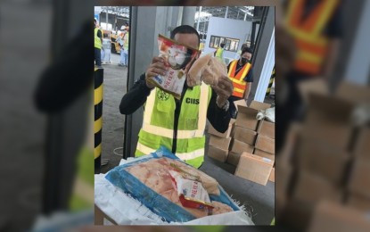 <p><strong>SMUGGLED AGRICULTURAL GOODS. </strong>A Customs officer shows smuggled poultry products seized from a shipment examined at the Manila International Container Port on June 29. The shipment worth PHP30 million was initially declared as containing hot pot balls.<em> (Photo courtesy of BOC) </em></p>