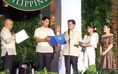 <p><strong>PLEDGE OF SERVICE</strong>. Former Negros Occidental third district congressman Alfredo Abelardo Benitez takes his oath as the 43rd mayor of Bacolod City before Barangay Granada village head Alfredo Talimodao Jr. in rites held at the Government Center grounds on Friday night (July 1, 2022). With him are his wife Dominique “Nikki” Lopez, and their children Bettina Marie and Javier Miguel, who is the new mayor of Victorias City. <em>(PNA photo by Nanette L. Guadalquiver)</em></p>