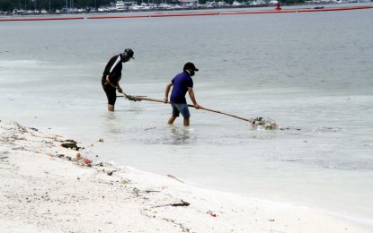 <p><strong>KEEPING IT CLEAN.</strong> Workers of the Manila Department of Public Services remove trash and other debris from the Manila Bay Dolomite Beach along Roxas Boulevard on July 2, 2022. The environment department reported improving water quality in the bay due to continued rehabilitation. <em>(PNA photo by Rico H. Borja)</em></p>