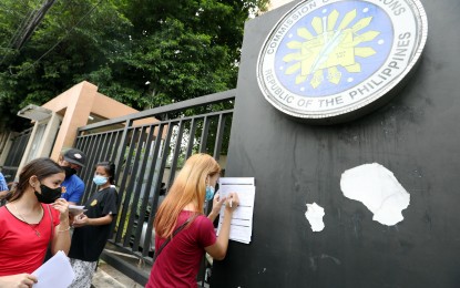 <p><strong>VOTER SIGN-UP. </strong>A woman fill up a voter's registration form outside the Commission on Elections (Comelec) office along Misamis Street in Quezon City on July 4, 2022. The poll body has moved the resumption of voter registration activities to Dec. 12. <em>(PNA file photo by Joey O. Razon)</em></p>