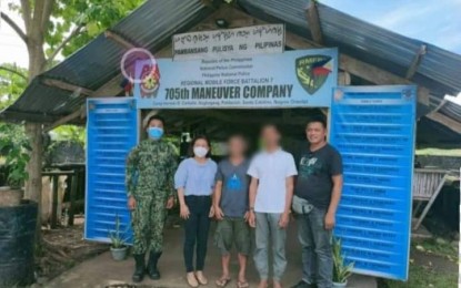 <p><strong>SURRENDER</strong>. Two members of the CPP-NPA surrendered to the 705th Maneuver Company of the Philippine National Police in Sta. Catalina, Negros Oriental. Mayor Peve Ligan (2nd from left) facilitated the interview. <em>(Photo courtesy of the Negros Oriental Provincial Police Office)</em></p>