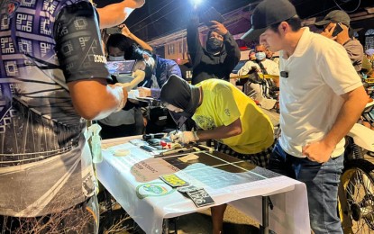 <p><strong>NEUTRALIZED.</strong> Mayor John Dalipe (in black baseball cap) watches as an undercover agent conducts an inventory on the pieces of evidence seized from the slain top 5 drug personality, Reynante Álvarez (not in photo) in Zamboanga City. Alvarez allegedly resisted and was killed in a shootout with police officers Sunday evening (July 3, 2022) in Barangay Tugbungan of the city. <em>(Photo lifted from Dalipe's Facebook Page)</em></p>