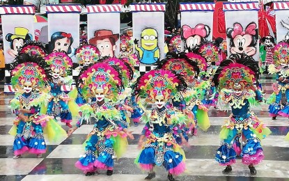<p><strong>FESTIVAL OF MANY FACES</strong>. A group of MassKara performers showcasing their dance skills and colorful costumes during the festival’s 40th year celebration at the Bacolod Public Plaza in October 2020. The festivity returns this year two years after it was shelved due to the coronavirus disease 2019 pandemic. <em>(PNA Bacolod file photo)</em></p>