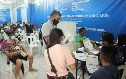 <p><strong>VOTER SIGN-UP </strong>A local Commission on Elections (Comelec) personnel (2nd from right) checks the documents given by registrant at the satellite voter registration center at SM City Dasmarinas, Cavite on July 6, 2022. The Comelec is set to resume the voter registration for the 2025 midterm elections from Feb. 12 to Sept. 30, 2024. <em>(PNA file photo)</em></p>