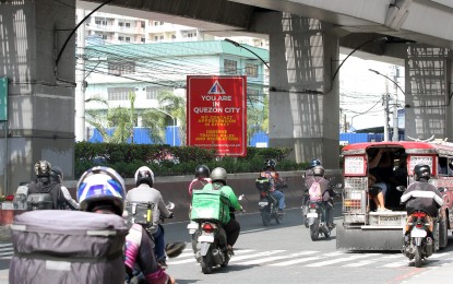 <p><strong>WARNING SIGN.</strong> Motorists pass by a no-contact apprehension sign along Aurora Boulevard in Quezon City on July 6, 2022. The MMDA on Thursday (Aug. 18, 2022) backed the no-contact apprehension policy of some local governments in the region despite calls to suspend and review such policies due to allegations of "excessive fines." <em>(PNA photo by Joey O. Razon)</em></p>