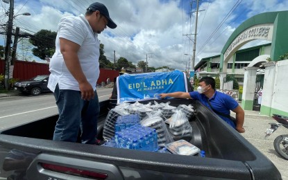 <p><strong>FREEBIES.</strong> In celebration of Eid al-Adha, the Bangsamoro Ports Management Authority distributes food packs to traffic enforcers, security and uniformed personnel on duty, and construction workers, among others, around Cotabato City in this photo released on Friday (July 8, 2022). The feast on July 9, which celebrates prophet Abraham's faithfulness to God by his willingness to sacrifice his son and marks the end of the yearly Hajj pilgrimage, is a regular non-working holiday nationwide. <em>(Photo courtesy of the Bangsamoro Ports Management Authority)</em></p>