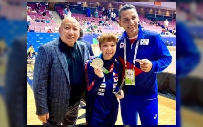 <p><strong>A GOLD IN KARATE</strong>. Filipino-Japanese Junna Tsukii (center) shows her gold medal after winning the women's kumite -50kg event at the World Games in Birmingham, Alabama on Friday (July 8, 2022). With her are Karate Pilipinas president Richard Lim (left) and national team head coach Okay Arpa. <em>(Photo courtesy of Karate Pilipinas)</em></p>