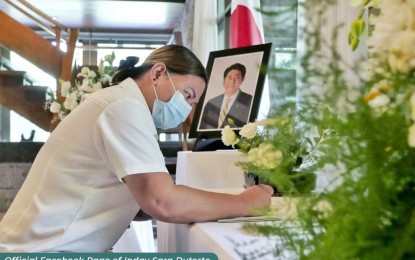 <p><strong>GREAT LEADER</strong>. Vice President Sara Z. Duterte writes a letter in honor of former Japanese Prime Minister Shinzo Abe at the official residence of Ambassador of Japan to the Philippines Kazuhiko Koshikawa on Monday (July 11, 2022). Duterte said she joined the Filipino people in condemning “the senseless act of violence that claimed the life of a great leader.” <em>(Photo courtesy of Office of the Vice President)</em></p>