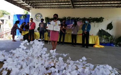 <p><strong>GRADUATION</strong>. A mother, Felipa Padasas, shows her household graduation diploma during the first ceremony held in Western Visayas on March 26, 2021 in Anini-y town. Jeffrey Gabucay, Antique Provincial Link of the Pantawid Pamilyang Pilipino Program, said on Tuesday (July 12, 2022) they are now validating 6,234 additional households for possible graduation from the program. <em>(PNA file photo by Annabel Consuelo J. Petinglay)</em></p>