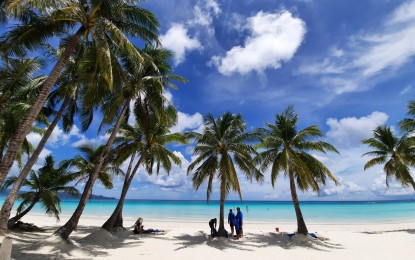 <p><strong>TOP DESTINATION.</strong> Tourists rest under the shade of Boracay palm trees. The famed white-sand beach is only one of the Philippines' many world-class destinations that attract thousands of local and foreign visitors annually.<em> (PNA file photo)</em></p>