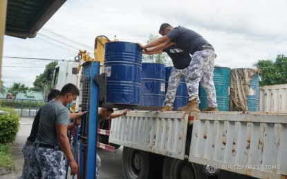 <p><strong>DONATION.</strong> Philippine Coast Guard Personnel haul drums containing unmarked diesel at the Port of Clark on July 8, 2022. The port seized some 6,357.80 liters of unmarked diesel fuel in September 2021 through the implementation of a Letter of Authority (LOA) issued by Commissioner Rey Leonardo Guerrero. <em>(Photo courtesy of BOC-Port of Clark)</em></p>