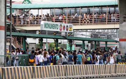 <p><strong>WAITING FOR BUSES.</strong> Passengers queue at the Monumento station of the Epifanio Delos Santos Avenue carousel in Caloocan City on July 13, 2022. To address long queues at stations and the return of students to in-person classes next month, Department of Transportation (DOTr) Secretary Jaime Bautista with the Land Transportation Franchising and Regulatory Board (LTFRB) chairperson Cheloy Garafil met with executives of the two bus consortia operating at the EDSA carousel to maximize their deployment of buses during rush hours. <em>(PNA photo by Joey O. Razon)</em></p>