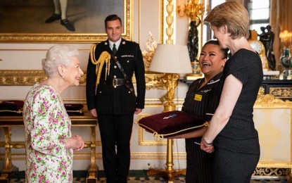 <p><strong>PINOY PRIDE</strong> Queen Elizabeth II presents the George Cross to Filipina nurse May Parsons at Windsor Castle on July 12, 2022. Senators adopted two resolutions honoring the Filipino nurse. (<em>Photo courtesy of The Royal Family)</em></p>