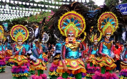 <p><strong>MASSKARA DANCERS</strong>. MassKara Festival dancers in colorful costumes during the street dance competition in 2018. The festival of “many faces” will return in October for its 43rd edition after a two-year respite due to the Covid-19 pandemic.<em> (PNA Bacolod file photo)</em></p>