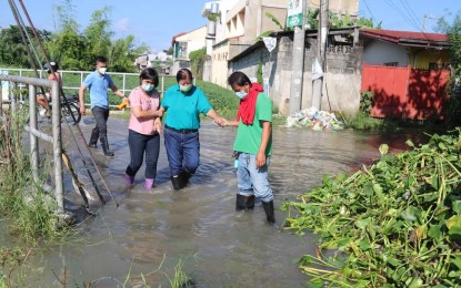 <p><strong>PERENNIAL FLOODING</strong>. Dagupan City Mayor Belen Fernandez (2nd from right) wades through a flooded street in Barangay Pogo Grande in Dagupan City on Friday (July 15, 2022). The city experiences perennial flooding due to high tides or heavy rains. <em>(Photo courtesy of City Information Office)</em></p>