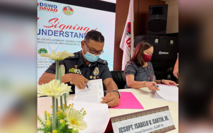 <p><strong>MARKET OPPORTUNITIES.</strong> Chief Supt. Isabelo Cartin Jr., director of the Bureau of Jail Management and Penology 11 (Davao region) (left), and lawyer Vanessa Goc-ong, director of the Department of Social Welfare and Development 11, sign a memorandum of understanding on July 15, 2022 to give market opportunities to qualified community-based Sustainable Livelihood Program Associations. The initiative forms part of the monitoring and capacity-building efforts of the SLP to agriculture and livestock groups across the region. <em>(Photo courtesy of BJMP-11)</em></p>