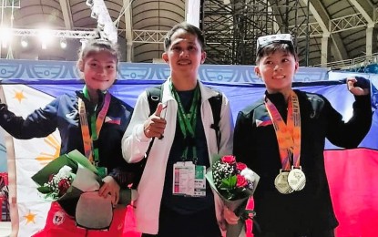 <p><strong>ZAMBOANGA’S PRIDE.</strong> Gold winners Rosalinda Faustino (left) and Rosegie Ramos (right) with coach Allen Drayfus Diaz during the awarding ceremony of the Asian Youth and Junior Weightlifting Championships in Tashkent, Uzbekistan on Tuesday (July 19, 2022). The Philippines now has 12 gold medals. <em>(Contributed photo)</em></p>