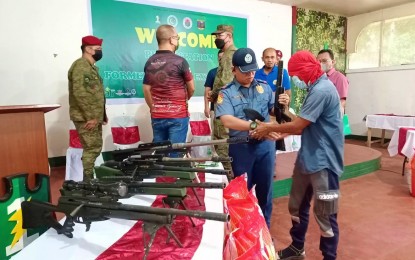 <p><strong>DISGRUNTLED EXTREMISTS.</strong> One of the 11 Bangsamoro Islamic Freedom Fighters (BIFF) hands over his rifle to military authorities following their surrender Wednesday (July 20, 2022) in Sultan Kudarat, Maguindanao. The BIFF men said they felt disgruntled in fighting a lost cause.<em> (Photo courtesy of Radio DXMS - Cotabato)</em></p>