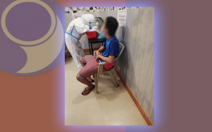 <p><strong>COVID VIGILANCE.</strong> A nurse in her protective gear (left) extracts a sample from a suspected Covid-19 patient inside an inn that was temporarily converted into an isolation facility in Cagayan de Oro City in 2021. Mayor Rolando Uy on Thursday (July 21, 2022) says he will retain such setup as Covid-19 cases in the city have reached double digits anew. <em>(Contributed photo)</em></p>