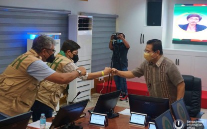 <p><strong>FOR BARMM’S HEALTH.</strong> Bangsamoro Autonomous Region in Muslim Mindanao (BARMM) Chief Minister Ahod Ebrahim (right) welcomes with a fist bump Department of Health Officer-In-Charge Maria Rosario Vergeire (center) and DOH Undersecretary Dr. Abdullah Dumama at the BARMM’s chief minister’s office in Cotabato City on Thursday (July 21, 2022). Vergeire assured BARMM officials of her all-out support for the ongoing coronavirus disease 2019 vaccination program in the region. <em>(Photo courtesy of Bangsamoro Information Office - BARMM)</em></p>