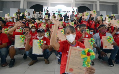 <p><strong>NEW LANDOWNERS</strong>. Agrarian reform beneficiaries from the province of Tarlac show their certificates of land ownership award (CLOAs) awarded by the Department of Agrarian Reform (DAR) on Thursday (July 21, 2022). Aside from the distribution of CLOAs, the DAR also turned over various farm machinery and equipment to ARB organizations (ARBOs) through its Climate Resilient Farm Productivity Support Project (CRFPSP). <em>(Photo courtesy of DAR-Tarlac)</em></p>