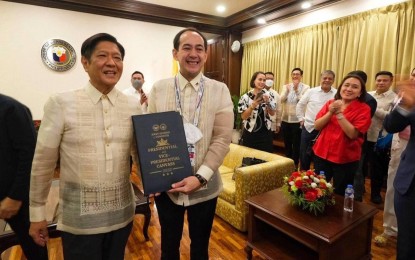 <p><strong>STRONG BOND.</strong> Then-President-elect Ferdinand Marcos Jr. (left) and Victor Rodriguez hold the official election canvass results during the Chief Executive’s official proclamation at the House of Representatives in Quezon City on May 25, 2022. Rodriguez branded as mere hearsay a rumor that he has resigned as Executive Secretary. <em>(Photo courtesy of Atty. Vic Rodriguez Facebook)</em></p>