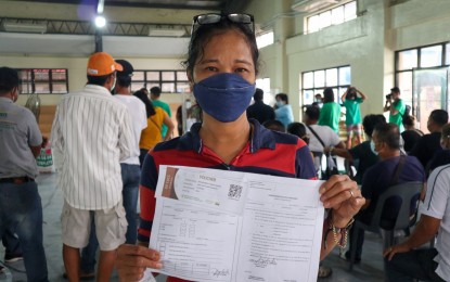 <p><strong>DISCOUNT VOUCHER</strong>. A farmer-beneficiary shows the fertilizer discount voucher that was provided by the Department of Agriculture in Zaragoza, Nueva Ecija in this undated photo. She is one of the 28 of the 2,250 beneficiaries of the program this wet cropping season who have so far received the voucher.<em> (Photo courtesy of DA-Region 3)</em></p>