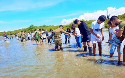 <p><strong>MANGROVE REFORESTATION.</strong> Volunteers plant 20,000 mangrove seedlings in mudflats at the boardwalk vicinity in Tanjay City, Negros Oriental on July 23, 2022. The Allied Mangrove Planting Organizations in Negros Oriental aims to reach its goal of planting 600,000 mangrove trees by October.<em> (Photo courtesy of Sidney Lee)</em></p>