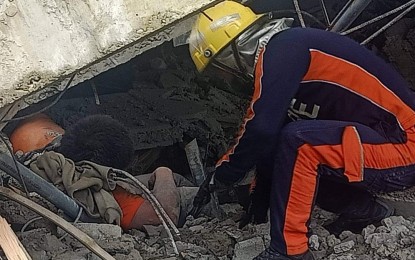 <p>RESCUE. A fire officer in Benguet pulls a victim out of a rubble in Buyagan, La Trinidad, Benguet after a magnitude 7 earthquake hit several provinces in Northern Luzon on Wednesday (July 27, 2022). The victim eventually died while undergoing treatment at the Benguet General Hospital. <em>(PNA photo courtesy of PNP)</em></p>
