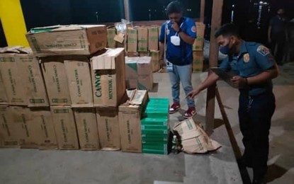 <p><strong>SMUGGLED CIGARETTES.</strong> Police and Bureau of Customs (BOC) personnel inspect the smuggled cigarettes they seized near Manalilpa Island, Zamboanga City on Thursday night (July 28, 2022). The police-BOC team was on sea patrol when they spotted a motorboat loaded with smuggled cigarettes valued at PHP2.4 million.<em> (Photo courtesy of Area Police Command-Western Mindanao)</em></p>
