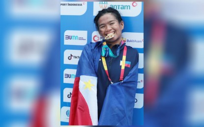 <p><strong>TRIPLE GOLD MEDALIST</strong>. Rookie Angel Otom takes a bite at her gold medal after winning the women’s 50-meter butterfly S5 event on the way to emerging as the country’s first triple gold medalist in the 11th ASEAN Para Games at the Jatadiri Sports Complex pool in Semarang, Indonesia on Thursday (Aug. 4, 2022). The Philippines has now 19 gold, 16 silver and 34 bronze medals. <em>(Photo courtesy of Team Philippines)</em></p>