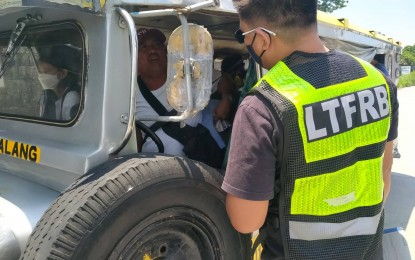 <p><strong>'COLORUM'</strong>. A Land Transportation Franchising and Regulatory Board (LTFRB) 3 (Central Luzon) enforcer apprehends a “colorum” or illegal public utility vehicle in this undated photo. The LTFRB-3 said it impounded six illegal public utility vehicles in July. <em>(Photo courtesy of LTFRB-3)</em></p>