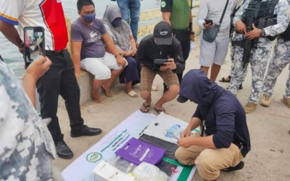 <p><strong>ANTI-DRUG OP.</strong> Authorities arrest two suspected big time drug traffickers (seated) in a buy-bust  on Tuesday (Aug. 9, 2022) near the port of Bongao, Tawi-Tawi. The suspects yielded a kilo of suspected shabu worth PHP6.8 million.<em> (Photo courtesy of Area Police Command-Western Mindanao)</em></p>