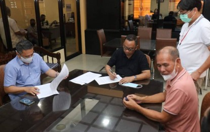 <p><strong>INVESTOR.</strong> San Jose de Buenavista Mayor Elmer Untaran (center) signs the contract of lease with IXL Solutions Philippines chief executive officer Addrian Funtelar (left) for the lease of government space at the second floor of the Business Park on Aug. 8, 2022. The call center will give employment opportunities to up to 150 residents.<em> (Photo courtesy of San Jose de Buenavista LGU)</em></p>