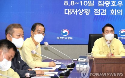 <p>President Yoon Suk-yeol (R) presides over an emergency meeting at the government complex in Seoul on Aug. 10, 2022, to check countermeasures against record torrential rain in Seoul and surrounding areas. <em>(Yonhap)</em></p>