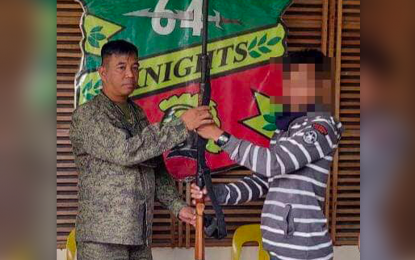 <p><strong>SURRENDER.</strong> Basilan-based Abu Sayyaf member Totoh Akalun, 33, hands over a rifle to Lt. Col. John Ferdinand Lazo, the Army's 64th Infantry Battalion commander, when he surrendered Monday (August 8, 2022) in Basilan province. Akalun is a follower of Basilan-based Abu Sayyaf leader Pasil Bayali.<em> (Photo courtesy of JTF - Basilan)</em></p>