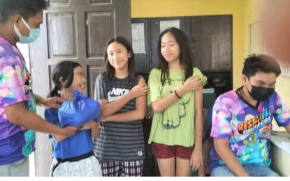 <p><strong>NUTRIVAC</strong>. Children receive a family pack after availing of the Covid-19 vaccination in this photo taken July 2022. The provincial government of Iloilo, to encourage more vaccine takers, will blend the Covid-19 jab campaign with its other programs, according to Iloilo Governor Arthur Defensor Jr. on Thursday (Aug. 11, 2022) <em>(Photo courtesy of Rose Ann B. Palec/Iloilo Provincial Health Office FB page)</em></p>