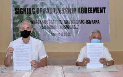 <p><strong>PARTNERSHIP</strong>. Negros Occidental Governor Eugenio Jose Lacson (left) and Bishop Patricio Buzon of the Diocese of Bacolod show the signed memorandum of agreement for the implementation of the tree-growing project, during rites held at the Capitol Social Hall in Bacolod City on Thursday (Aug. 11, 2022). The Diocese’s Social Action Center, together with the “Panggas” multi-sectoral alliance, has identified various schools as participants in the project. <em>(Photo courtesy of PIO Negros Occidental)</em></p>