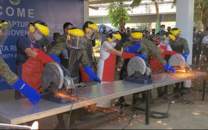 <p><strong>FIREARMS DESTRUCTION.</strong> Department of National Defense OIC Undersecretary Jose Faustino Jr. (extreme right) and National Security Adviser Clarita Carlos (center) lead the destruction of firearms belonging to the communist New People's Army on Thursday (Aug. 11, 2022) at the Eastmincom headquarters in Davao City.  At least 54 firearms were destroyed during the ceremony. <em>(PNA photo by Che Palicte)</em></p>