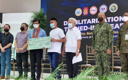<p><strong>PEACE OFFERING.</strong> Interior and Local Government Secretary Benjamin Abalos Jr. (3rd from left) hands over a giant check replica of financial aid to a former New People's Army rebel in a ceremony at the Provincial Government Complex in Pagadian City, Zamboanga del Sur on Friday (Aug. 12, 2022). Abalos released a total of PHP3.06 million in financial aid to 27 ex-rebels via the Enhanced Comprehensive Local Integration Program. <em>(Photo courtesy of Area Police Command-Western Mindanao)</em></p>