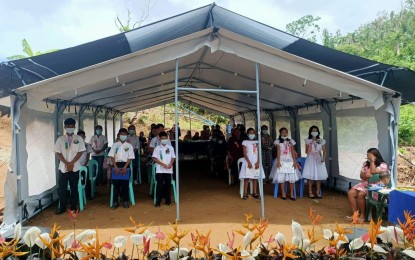 <p><strong>TEMPORARY CLASSROOM</strong>. Learners in Pansaan village in Maasin City, Southern Leyte attend graduation rites inside a tent set by UNICEF in this July 1, 2022 photo. Some students in Southern Leyte will attend classes in tents pending the completion of repair and reconstruction of classrooms damaged by recent destructive typhoons, the Department of Education reported on Tuesday (Aug. 16, 2022).<em> (Photo courtesy of UNICEF)</em></p>