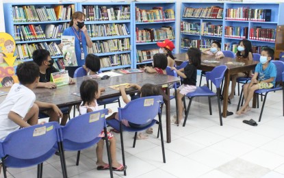 <p><strong>BATTLE VS. ILLITERACY.</strong> Quezon City Public Library staff Rosalie Teologo reads stories to children in Kamuning, Quezon City in this undated photo. A World Bank study released in June 2022 said learning poverty has increased by a third in low- and middle-income countries, with an estimated 70 percent of 10-year-olds unable to understand a simple written text. <em>(PNA photo by Robert Oswald P. Alfiler)</em></p>