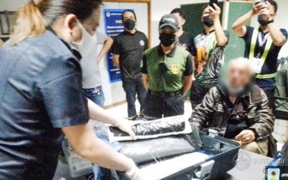 <p><strong>BIG CATCH.</strong> Anti-illegal drug operatives process the 21.215 kg of suspected shabu, with an estimated street value of PHP144.3 million, seized from a South African national (seated) at the Ninoy Aquino International Airport in Pasay City on Friday (Aug. 19, 2022). The illegal shipment was detected in the suspect’s luggage. <em>(Photo from BOC Facebook)</em></p>