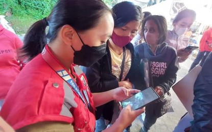 <p><strong>ONLINE REGISTRATION</strong>. An employee of the Department of Social Welfare and Development (DSWD) in Cordillera in Baguio City assists people applying for educational assistance. More than PHP4.45 million was released to over 1,400 students in Cordillera. <em>(PNA photo from DSWD-CAR FB)</em></p>